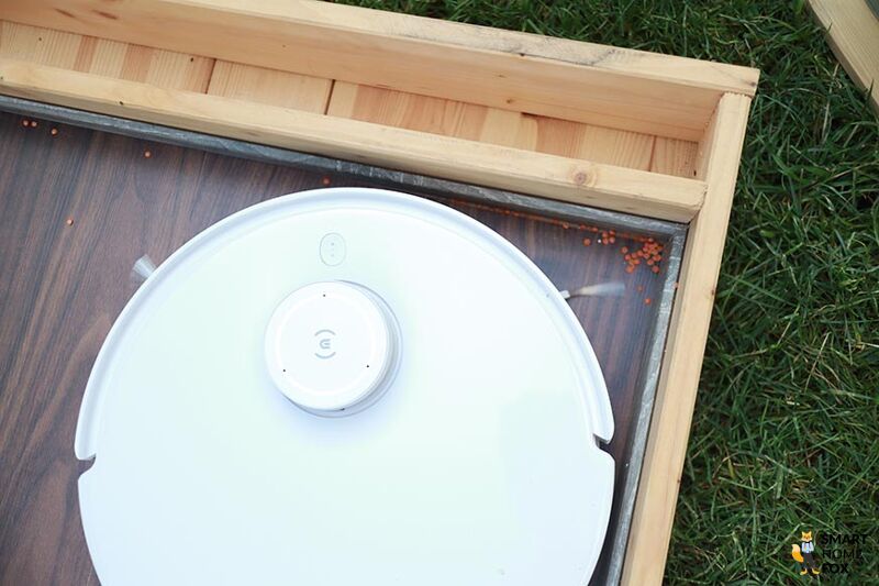 Der Ecovacs Deebot T10 saugt Schmutz aus einer Ecke heraus.